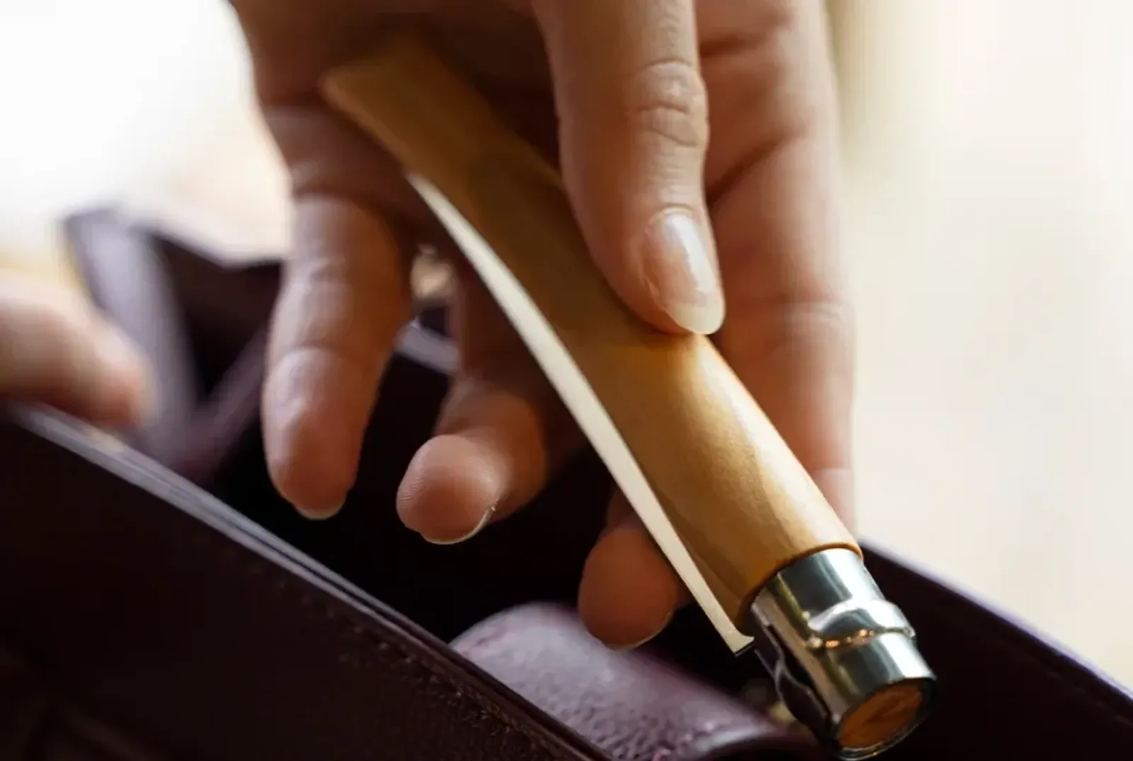 Opinel N08 Inox kniv med olivträ handtag hållen i hand - visar storlek och ergonomiskt grepp
