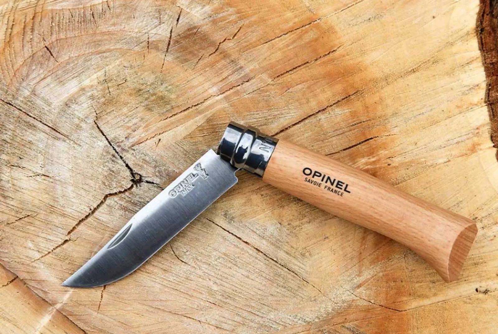 Opinel N08 Inox kniv med trähandtag på träyta - visar elegant rostfritt stål blad och klassisk design